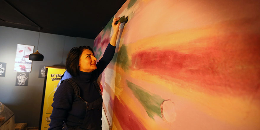 Masabaşı işten sıkılan kadın gri duvarlara renk katıyor