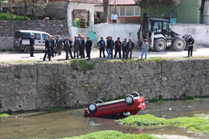 OTOMOBİL IRMAĞA UÇTU, SÜRÜCÜ YARALI KURTULDU