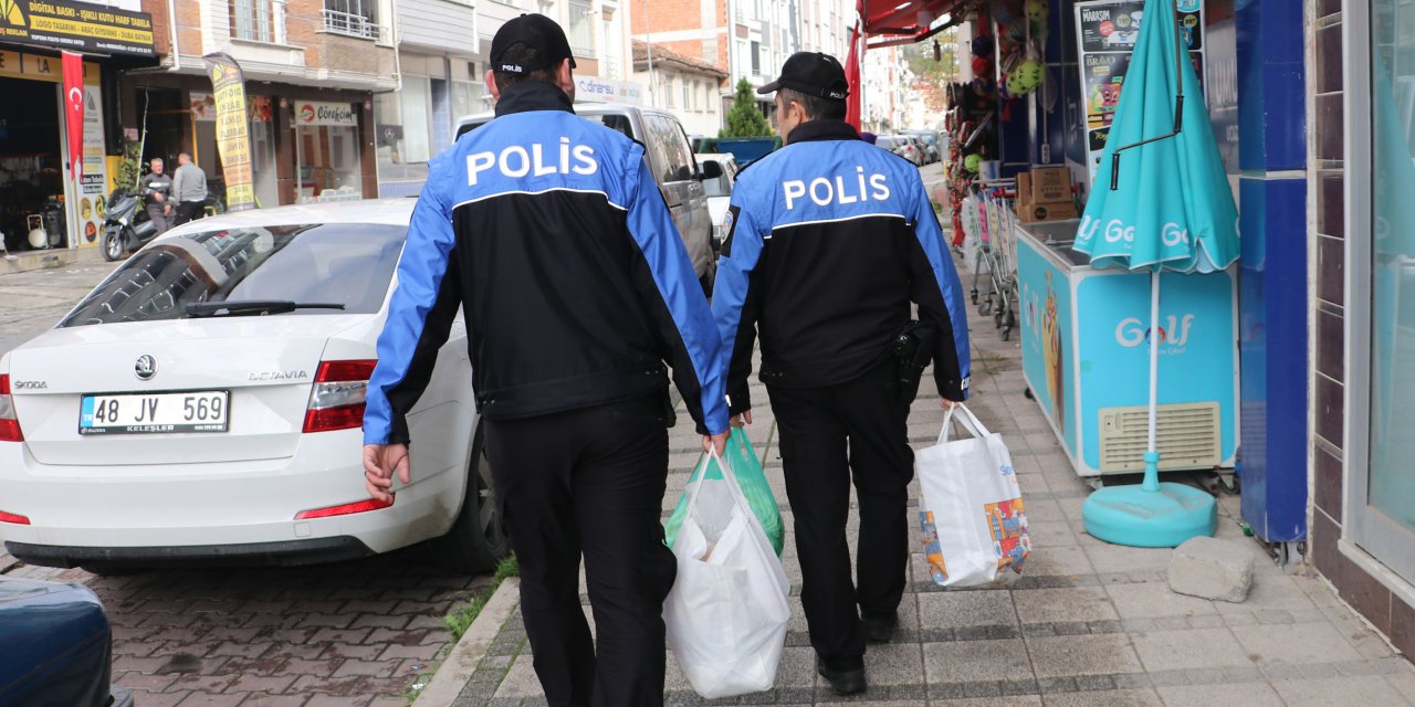 Polis ekipleri yaşlı kadının çantalarını taşıdı